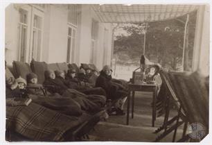 Миеджешин.  Дети, закутанные в одеяла, сидят на крыльце санатория "Медем" и слушают радио