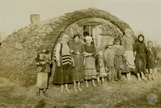 Jewish family that had been forced to flee their town pose outside their temporary home, a crude structure located on the road between Kovel and Riwne. Photographer Max Colton, Joint Distribution Committee, 1914-1918 Jewish family that had been forced to flee their town pose outside their temporary home, a crude structure located on the road between Kovel and Riwne. Photographer Max Colton, Joint Distribution Committee, 1914-1918
